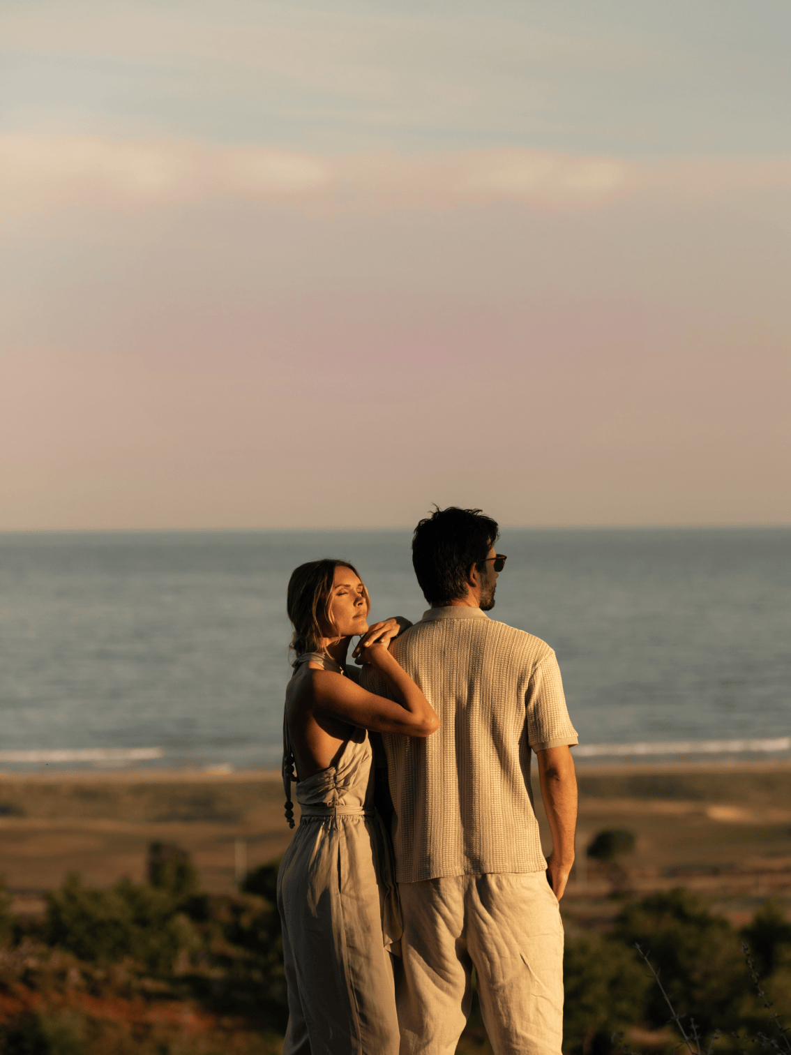 Casal a contemplar o mar ao pôr do sol em Palmares, Lagos.