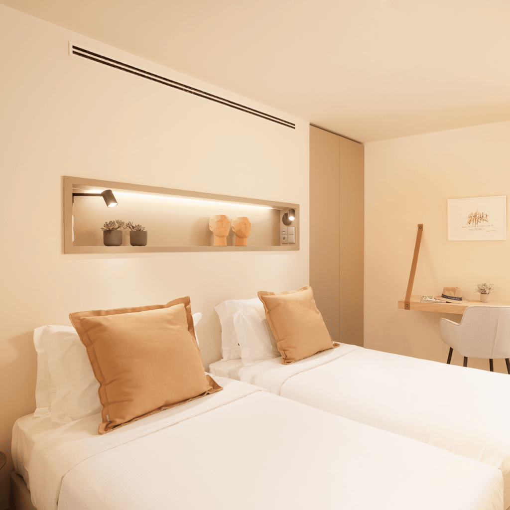Quarto twin do duplex em Palmares com decoração em tons neutros e detalhe decorativo na parede