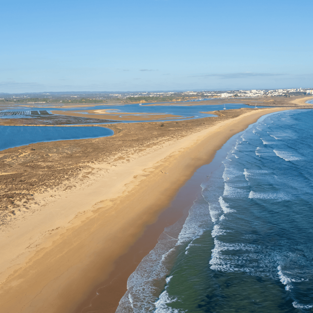 Vista aérea panorâmica da Meia Praia e da costa de Lagos, com a ria e o mar em destaque — natureza preservada num cenário paradisíaco do Algarve.
