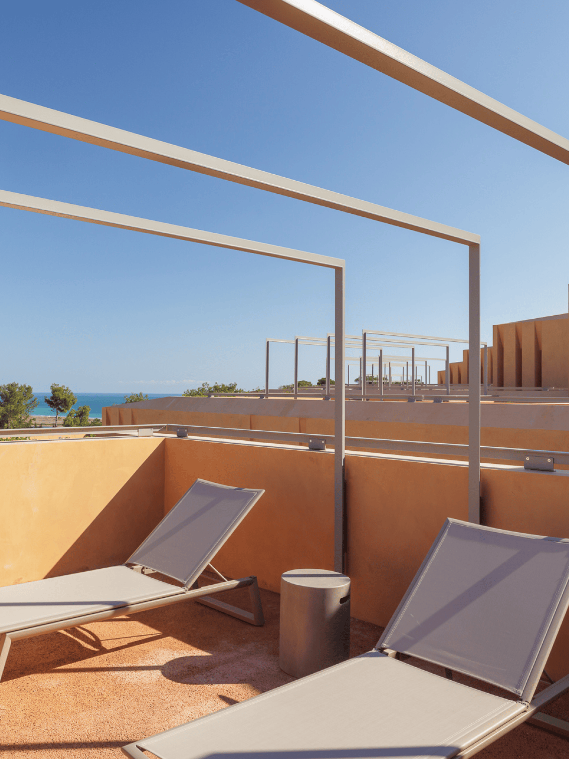 Espaço de solário com espreguiçadeiras modernas e vista para o mar no Palmares Living — arquitetura contemporânea em perfeita sintonia com o céu e oceano.