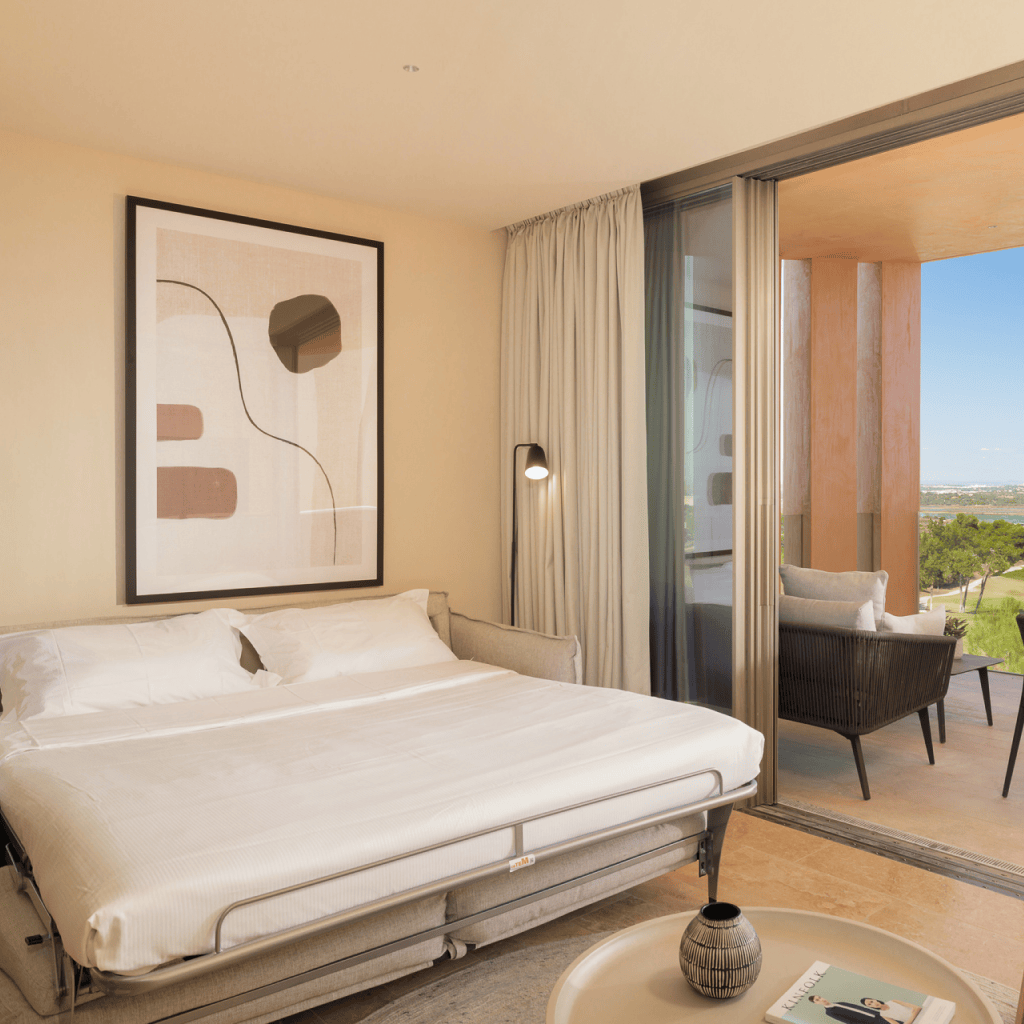 Quarto com cama de casal e acesso a terraço com vista mar na unidade T1 em Palmares.