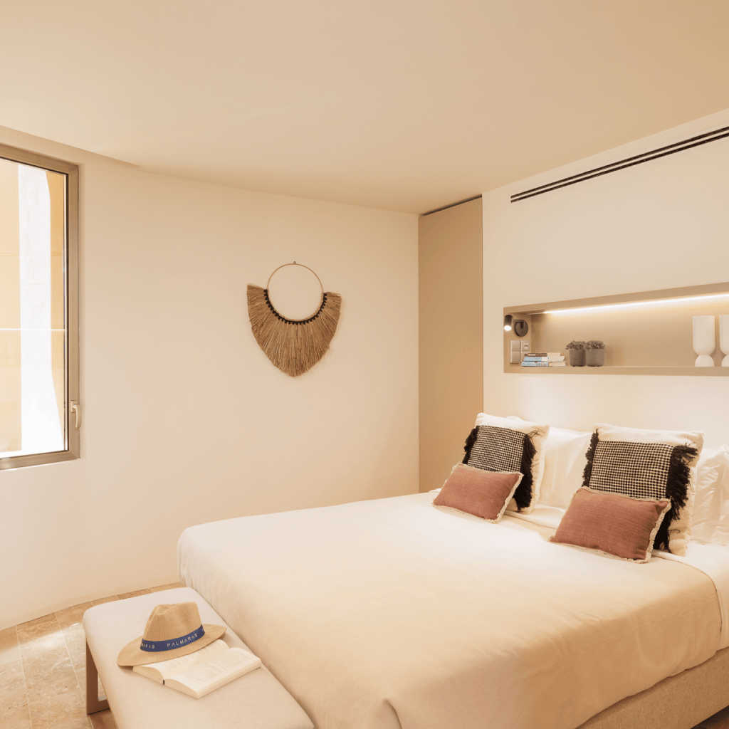 Quarto interior confortável com decoração natural na unidade T1 de Palmares Living.